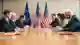 создай реалистичную фотографию встречи делегаций Евросоюза и США за конференц-столом с флагами ЕС и США на заднем плане